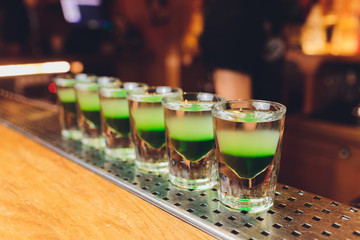 Barman make alcoholic shots with rum and liquor.