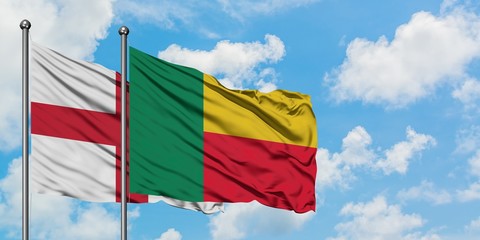 England and Benin flag waving in the wind against white cloudy blue sky together. Diplomacy concept, international relations.