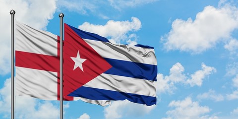 England and Cuba flag waving in the wind against white cloudy blue sky together. Diplomacy concept, international relations.