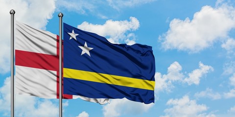 England and Curacao flag waving in the wind against white cloudy blue sky together. Diplomacy concept, international relations.