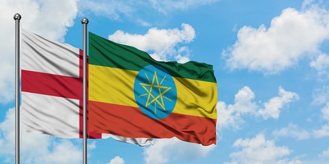 England and Ethiopia flag waving in the wind against white cloudy blue sky together. Diplomacy concept, international relations.