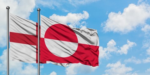 England and Greenland flag waving in the wind against white cloudy blue sky together. Diplomacy concept, international relations.