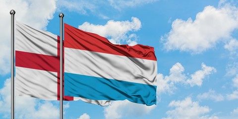 England and Luxembourg flag waving in the wind against white cloudy blue sky together. Diplomacy concept, international relations.