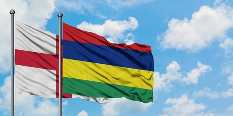 England and Mauritius flag waving in the wind against white cloudy blue sky together. Diplomacy concept, international relations.