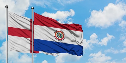 England and Paraguay flag waving in the wind against white cloudy blue sky together. Diplomacy concept, international relations.