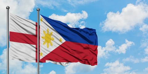 England and Philippines flag waving in the wind against white cloudy blue sky together. Diplomacy concept, international relations.