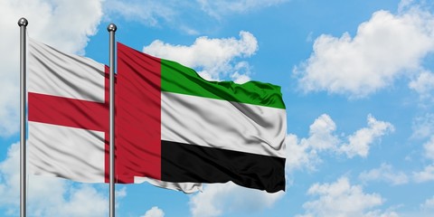 England and United Arab Emirates flag waving in the wind against white cloudy blue sky together. Diplomacy concept, international relations.