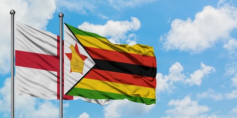 England and Zimbabwe flag waving in the wind against white cloudy blue sky together. Diplomacy concept, international relations.