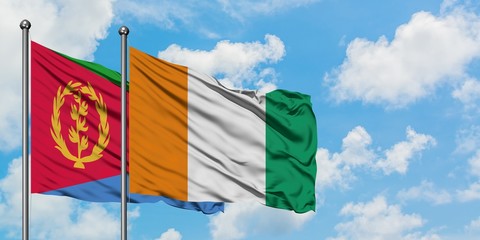 Eritrea and Cote D'Ivoire flag waving in the wind against white cloudy blue sky together. Diplomacy concept, international relations.