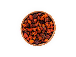 Dried Rowan or Sorbus berries in a wooden Cup on a white background