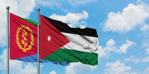 Eritrea and Jordan flag waving in the wind against white cloudy blue sky together. Diplomacy concept, international relations.