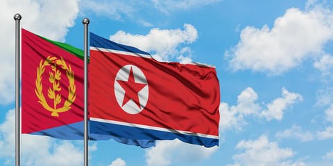 Eritrea and North Korea flag waving in the wind against white cloudy blue sky together. Diplomacy concept, international relations.