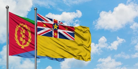Eritrea and Niue flag waving in the wind against white cloudy blue sky together. Diplomacy concept, international relations.