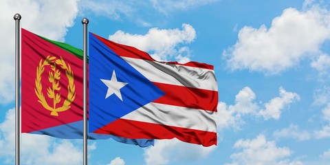 Eritrea and Puerto Rico flag waving in the wind against white cloudy blue sky together. Diplomacy concept, international relations.
