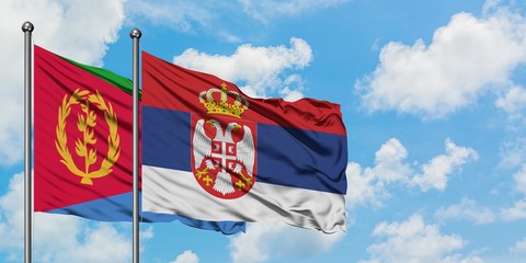 Eritrea and Serbia flag waving in the wind against white cloudy blue sky together. Diplomacy concept, international relations.