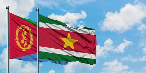 Eritrea and Suriname flag waving in the wind against white cloudy blue sky together. Diplomacy concept, international relations.