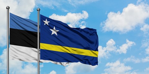 Estonia and Curacao flag waving in the wind against white cloudy blue sky together. Diplomacy concept, international relations.