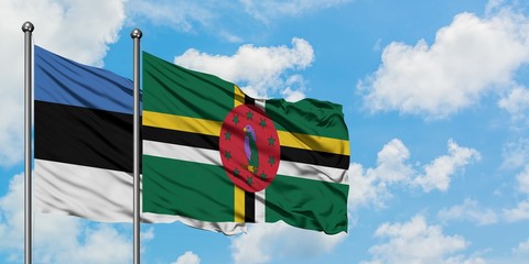 Estonia and Dominica flag waving in the wind against white cloudy blue sky together. Diplomacy concept, international relations.