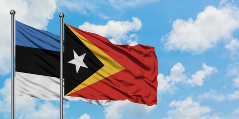 Estonia and East Timor flag waving in the wind against white cloudy blue sky together. Diplomacy concept, international relations.