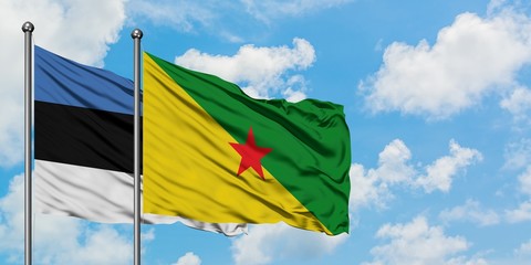 Estonia and French Guiana flag waving in the wind against white cloudy blue sky together. Diplomacy concept, international relations.