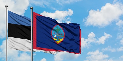 Estonia and Guam flag waving in the wind against white cloudy blue sky together. Diplomacy concept, international relations.