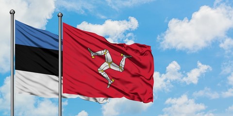 Estonia and Isle Of Man flag waving in the wind against white cloudy blue sky together. Diplomacy concept, international relations.