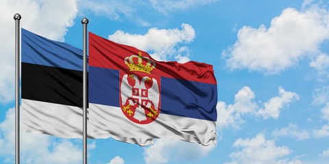 Estonia and Serbia flag waving in the wind against white cloudy blue sky together. Diplomacy concept, international relations.