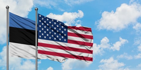 Estonia and United States flag waving in the wind against white cloudy blue sky together. Diplomacy concept, international relations.