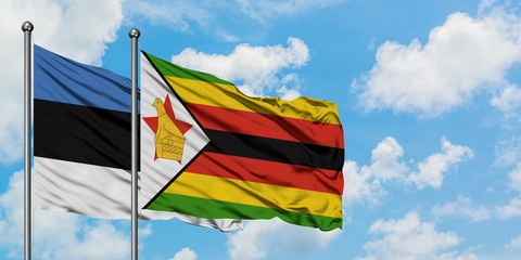 Estonia and Zimbabwe flag waving in the wind against white cloudy blue sky together. Diplomacy concept, international relations.