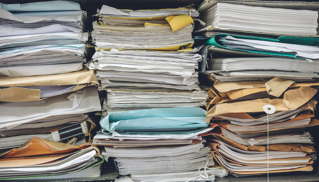 The stack of paper are old file, document, letter or contract look dirty with high layer and disorganized. It's must to reuse or reduce. pastel tone, Taken in the storage room in the office