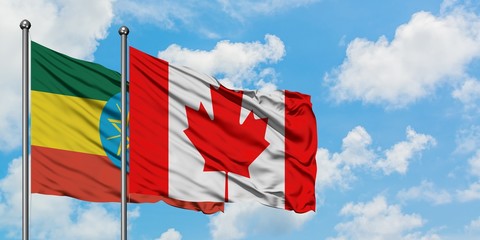 Ethiopia and Canada flag waving in the wind against white cloudy blue sky together. Diplomacy concept, international relations.
