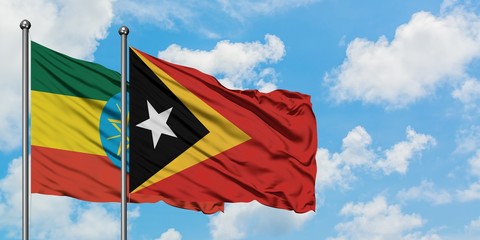 Ethiopia and East Timor flag waving in the wind against white cloudy blue sky together. Diplomacy concept, international relations.