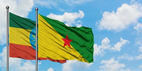 Ethiopia and French Guiana flag waving in the wind against white cloudy blue sky together. Diplomacy concept, international relations.