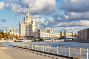 Fototapeta na wymiar View of famous stalin skyscraper on Kotelnicheskaya Embankment against pier of cruise ships on Moskva River in sunny autumn day