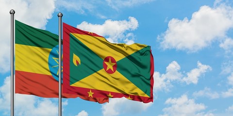 Ethiopia and Grenada flag waving in the wind against white cloudy blue sky together. Diplomacy concept, international relations.