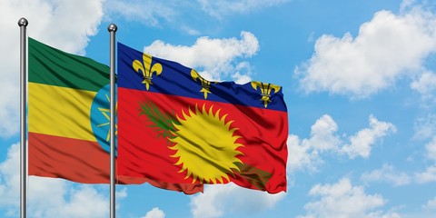 Ethiopia and Guadeloupe flag waving in the wind against white cloudy blue sky together. Diplomacy concept, international relations.