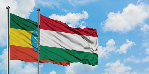 Ethiopia and Hungary flag waving in the wind against white cloudy blue sky together. Diplomacy concept, international relations.