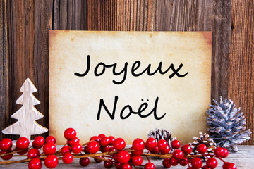 Obraz na płótnie Canvas Paper With French Text Joyeux Noel Merry Christmas. Christmas Decoration And Wooden Background