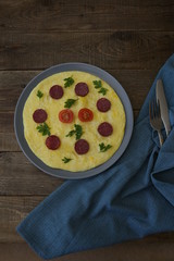 Omelette with sausage, tomatoes on the wooden rustic background. Italian omelet Frittata. Top view. Flat lay. Photo for menu. Food background, pattern, poster. With copy space for text. Vertical photo