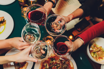 Clinking glasses with alcohol and toasting, party.
