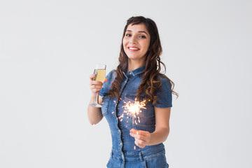People, celebration and holiday concept - Lovely woman with sparkler and glass of champagne over white background