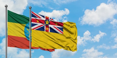 Ethiopia and Niue flag waving in the wind against white cloudy blue sky together. Diplomacy concept, international relations.
