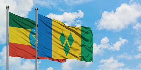 Ethiopia and Saint Vincent And The Grenadines flag waving in the wind against white cloudy blue sky...