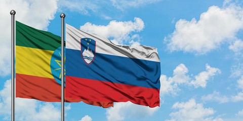 Ethiopia and Slovenia flag waving in the wind against white cloudy blue sky together. Diplomacy concept, international relations.