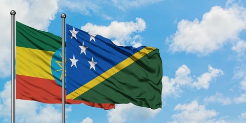 Ethiopia and Solomon Islands flag waving in the wind against white cloudy blue sky together. Diplomacy concept, international relations.