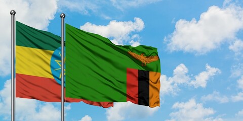 Ethiopia and Zambia flag waving in the wind against white cloudy blue sky together. Diplomacy concept, international relations.