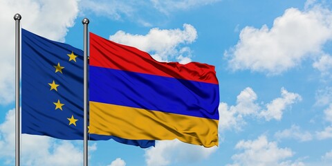 European Union and Armenia flag waving in the wind against white cloudy blue sky together. Diplomacy concept, international relations.