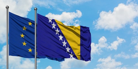 European Union and Bosnia Herzegovina flag waving in the wind against white cloudy blue sky together. Diplomacy concept, international relations.
