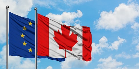European Union and Canada flag waving in the wind against white cloudy blue sky together. Diplomacy concept, international relations.
