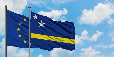 European Union and Curacao flag waving in the wind against white cloudy blue sky together. Diplomacy concept, international relations.